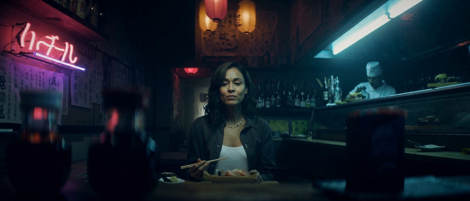 A woman and a rabbit-headed figure in a late-night diner booth